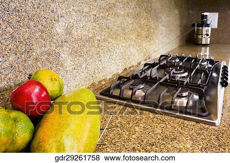 Fruits near a stove on a kitchen counter View Large Photo Image Stock Photo - Fruits near a stove on a kitchen counter. Fotosearch