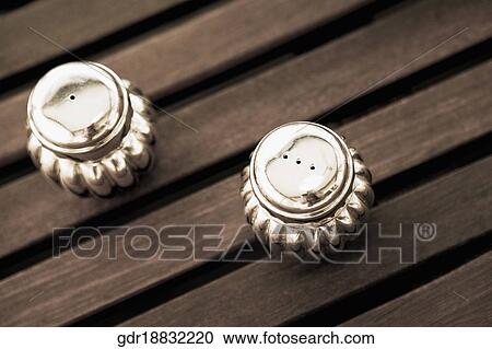 Stock Image - High angle view of salt shaker and a pepper shaker on a dining table. Fotosearch