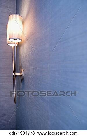 Stock Photo - Illuminated lamp mounted on the wall. Fotosearch