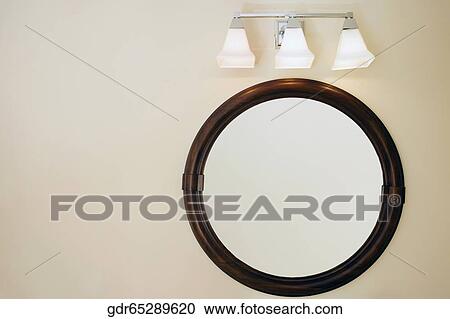 Lamp lit up over a bathroom mirror View Large Photo Image Stock Image - Lamp lit up over a bathroom mirror. Fotosearch