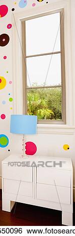 Stock Photograph - Lamp on a chest by a window. Fotosearch