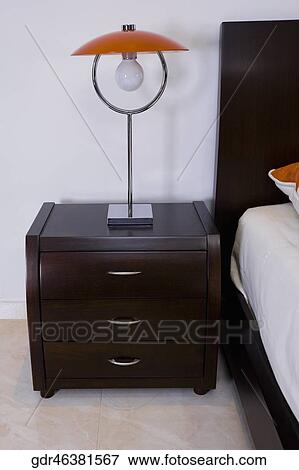 Lamp on a night table in the bedroom View Large Photo Image Stock Photo - Lamp on a night table in the bedroom. Fotosearch