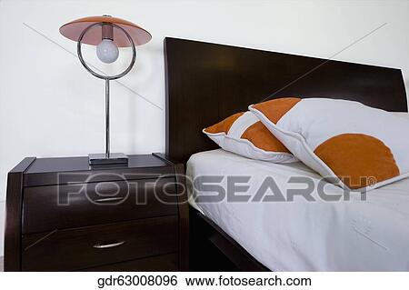 Lamp on a night table in the bedroom View Large Photo Image Stock Photograph - Lamp on a night table in the bedroom. Fotosearch