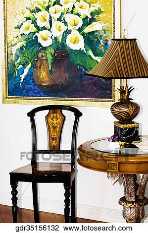 Lamp on a table beside a chair View Large Photo Image Stock Image - Lamp on a table beside a chair. Fotosearch