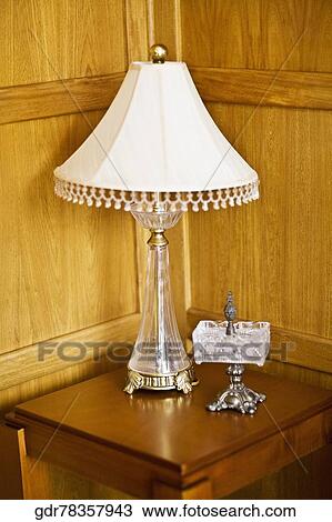 Lampshade and a showpiece on a stool View Large Photo Image Stock Image - Lampshade and a showpiece on a stool. Fotosearch