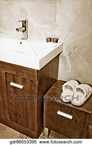 Stock Photography - Pair of slippers on a cabinet near a washbasin. Fotosearch