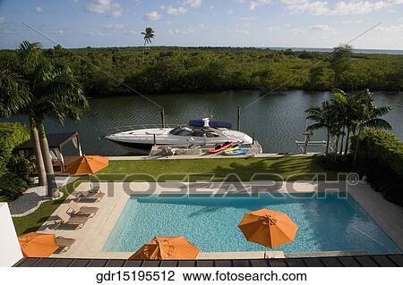 Patio umbrellas with lounge chairs at the poolside View Large Photo Image Stock Image - Patio umbrellas with lounge chairs at the poolside. Fotosearch