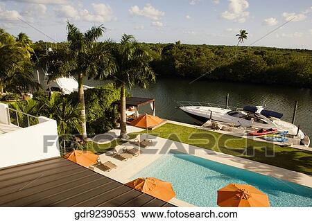 Patio umbrellas with lounge chairs at the poolside View Large Photo Image Stock Image - Patio umbrellas with lounge chairs at the poolside. Fotosearch