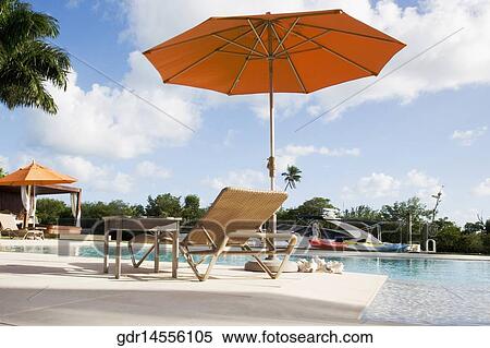 Patio umbrellas with lounge chairs at the poolside View Large Photo Image Stock Photography - Patio umbrellas with lounge chairs at the poolside. Fotosearch