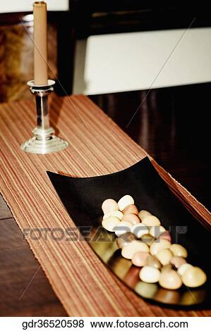 Stock Photo - Pebbles in a tray on a table. Fotosearch