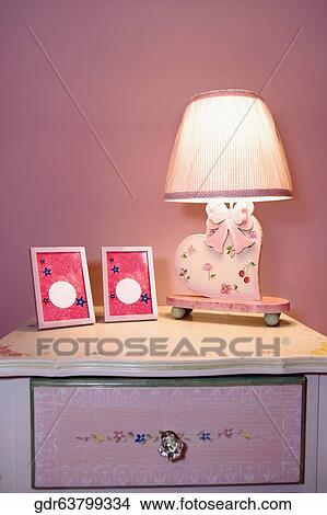 Picture frames and a lamp on a night table View Large Photo Image Picture - Picture frames and a lamp on a night table. Fotosearch