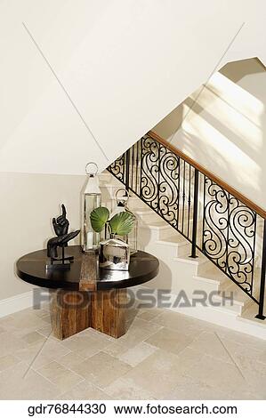 Stock Image - Show pieces on a table under a staircase. Fotosearch