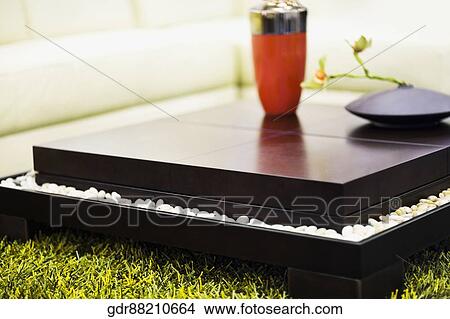 Picture - Showpieces on a table with a couch. Fotosearch