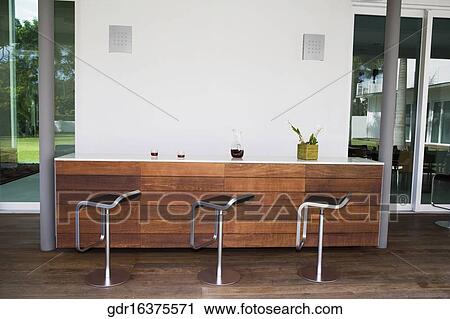 Stock Image - Stools in a row at a bar counter. Fotosearch