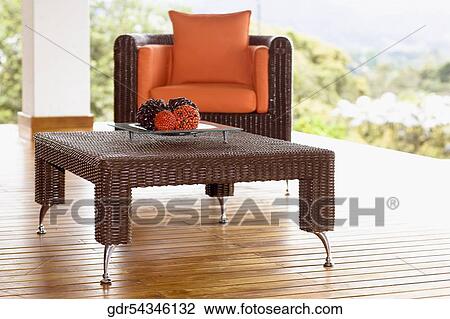 Stock Image - Table and an armchair on the patio. Fotosearch