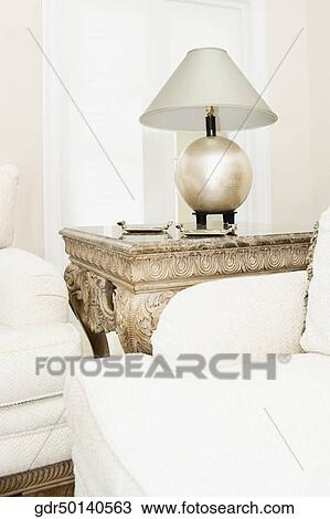 Table lamp on a table with couches View Large Photo Image Stock Image - Table lamp on a table with couches. Fotosearch