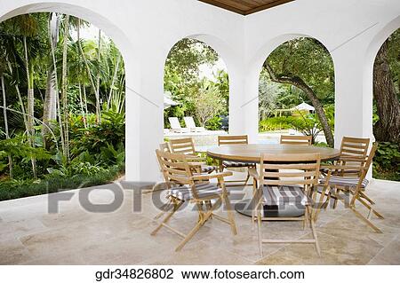 Table with chairs in a patio View Large Photo Image Stock Image - Table with chairs in a patio. Fotosearch