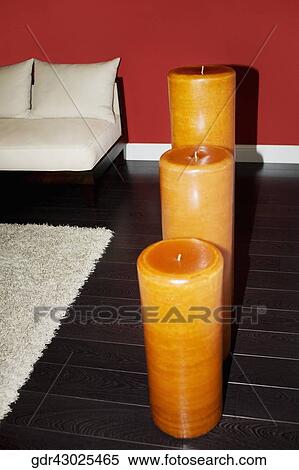 Stock Photography - Three candles on the floorboard. Fotosearch