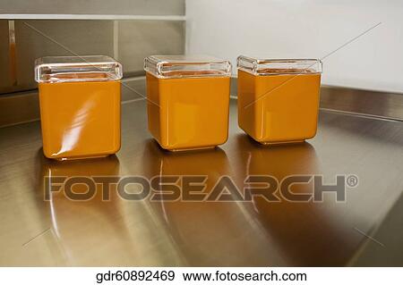 Three containers on a table View Large Photo Image Stock Photo - Three containers on a table. Fotosearch