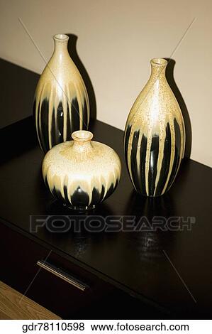 Three vases on a sideboard View Large Photo Image Stock Photo - Three vases on a sideboard. Fotosearch