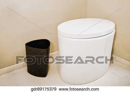 Stock Photo - Toilet bowl and wastepaper basket in the bathroom. Fotosearch