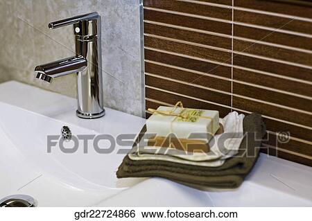 Toiletries near a faucet on a wash bowl View Large Photo Image Stock Photograph - Toiletries near a faucet on a wash bowl. Fotosearch