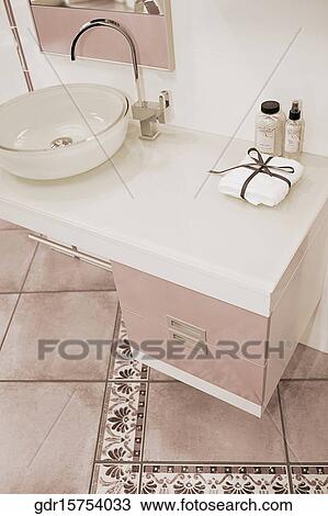 Toiletries near a wash bowl on a cabinet View Large Photo Image Stock Image - Toiletries near a wash bowl on a cabinet. Fotosearch