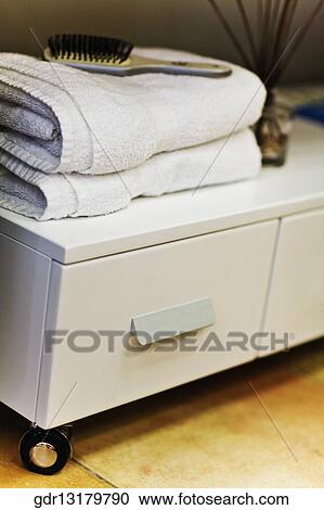 Towels with hairbrush on a cabinet in the bathroom View Large Photo Image Stock Image - Towels with hairbrush on a cabinet in the bathroom. Fotosearch