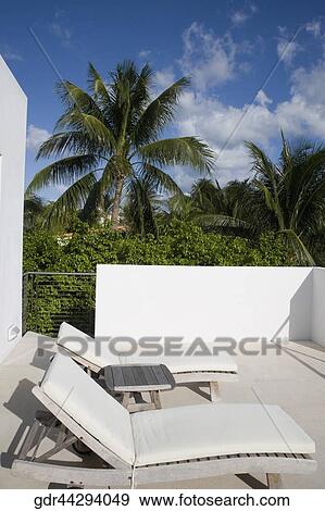Two reclining chairs in a balcony View Large Photo Image Stock Photo - Two reclining chairs in a balcony. Fotosearch