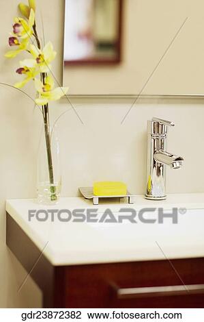 Stock Image - Vase and a bar of soap near a washbasin in the bathroom. Fotosearch