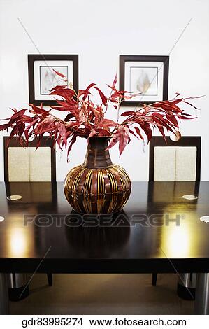 Vase with artificial leaves on a dining table View Large Photo Image Picture - Vase with artificial leaves on a dining table. Fotosearch