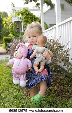Baby girl holding toys and walking in a lawn View Large Photo Image Stock Photography - Baby girl holding toys and walking in a lawn. Fotosearch