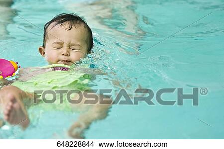 Baby girl in a swimming pool View Large Photo Image Picture - Baby girl in a swimming pool. Fotosearch