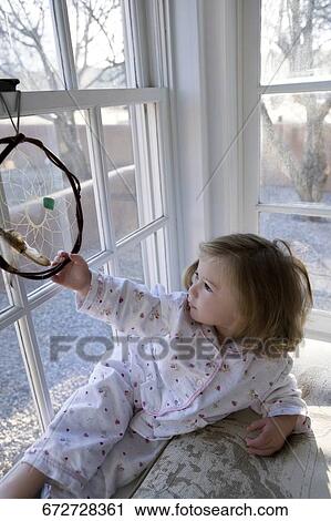 Baby girl looking through a window View Large Photo Image Stock Image - Baby girl looking through a window. Fotosearch