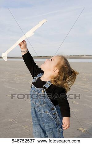 Baby girl playing with a model airplane on the beach View Large Photo Image Stock Photo - Baby girl playing with a model airplane on the beach. Fotosearch