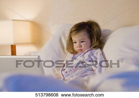 Stock Photo - Baby girl reclining on the bed. Fotosearch