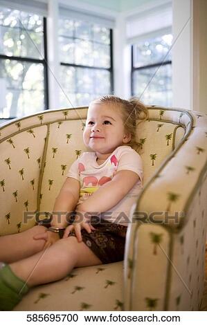 Baby girl sitting in an armchair and smiling View Large Photo Image Stock Image - Baby girl sitting in an armchair and smiling. Fotosearch