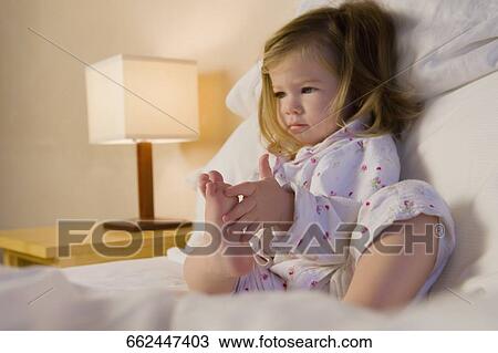 Baby girl sitting on the bed View Large Photo Image Stock Image - Baby girl sitting on the bed. Fotosearch