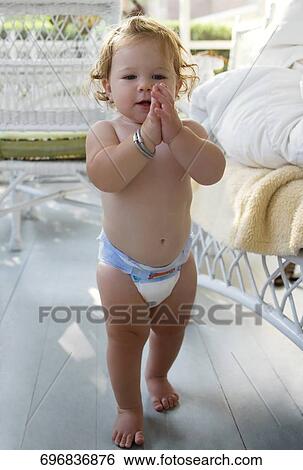 Baby girl standing in a porch and clapping View Large Photo Image Stock Photograph - Baby girl standing in a porch and clapping. Fotosearch