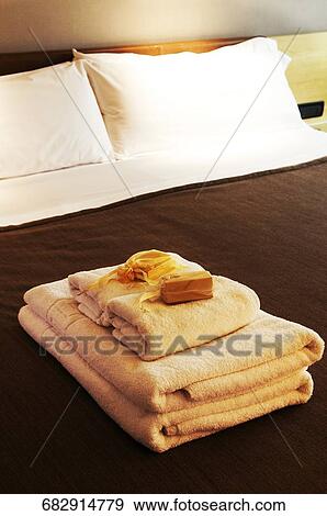 Stock Photo - Bar of soaps on stack of towels. Fotosearch