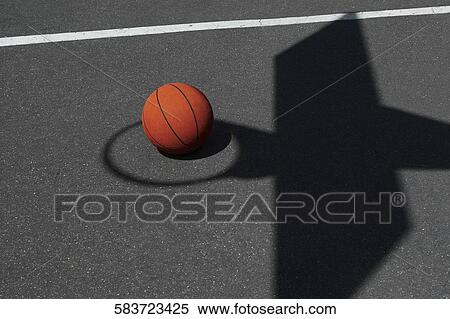 Basketball in the middle of a shadow hoop View Large Photo Image Stock Photography - Basketball in the middle of a shadow hoop. Fotosearch