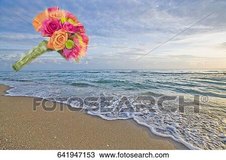 Stock Image - Bouquet of flowers in mid-air on the beach. Fotosearch