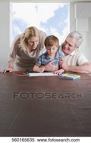 Boy doing homework with the help of his mother and grandfather View Large Photo Image Stock Photography - Boy doing homework with the help of his mother and grandfather. Fotosearch