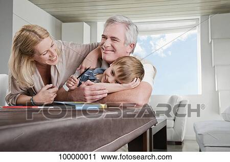 Boy smiling with his mother and grandfather View Large Photo Image Stock Image - Boy smiling with his mother and grandfather. Fotosearch