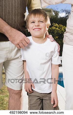 Boy standing with his parents at the poolside View Large Photo Image Picture - Boy standing with his parents at the poolside. Fotosearch