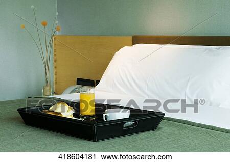 Stock Image - Breakfast tray on the bed. Fotosearch