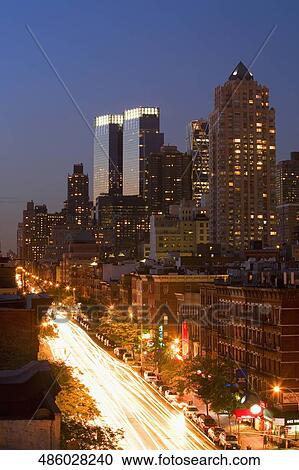Stock Image - Buildings lit up at night in a city, Manhattan, New York City, New York State, USA. Fotosearch