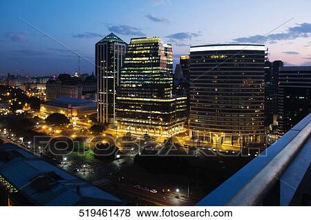 Buildings lit up at night in a city View Large Photo Image Stock Photo - Buildings lit up at night in a city. Fotosearch