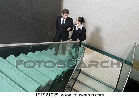 Stock Photo - Businessman and a businesswoman moving up stairs. Fotosearch