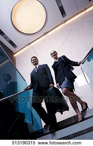 Businessman and a businesswoman moving down stairs View Large Photo Image Stock Photography - Businessman and a businesswoman moving down stairs. Fotosearch